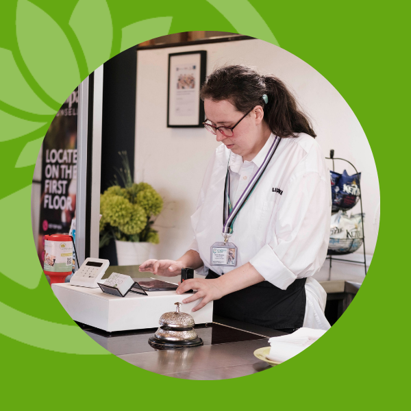 Young woman who works at Lily and Lime using the till.